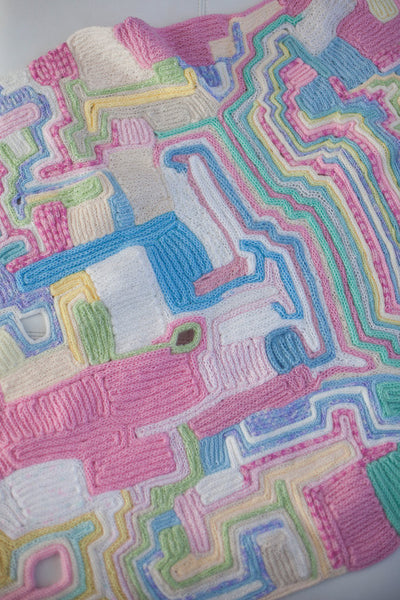 baby cot blanket made of recycled wool scraps. All pastel colors. Looks like the land from above